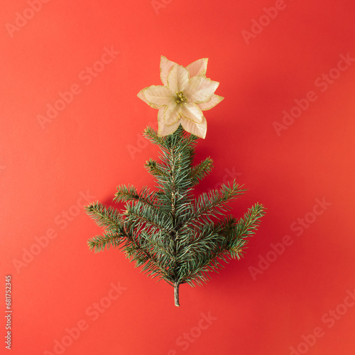 Creative layout made of Christmas tree pine branch. Red holiday background. Flat lay.