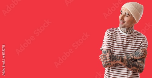 Tattooed young man on red b...