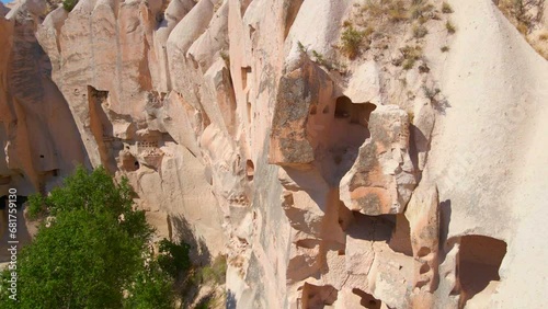 Embark on a visual journey with this mesmerizing aerial stock video capturing the essence of Cappadocia's cave dwellings near Goreme, Turkey. The bird's eye perspective unveils the unique charm of photo