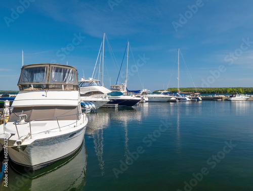 Beautiful morning scene  with motor boats and sailboats moored to the docks in the marina.