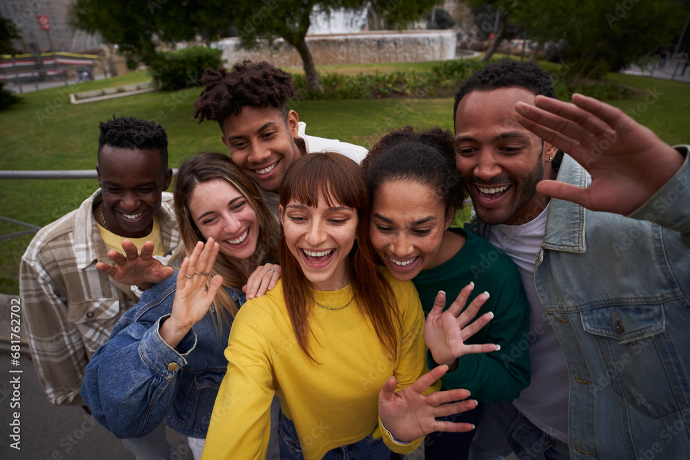 Young people embrace posing for a group portrait looking at the camera outside. Smiling friends of the millennial generation. Young guys and girls having fun together Young people embrace posing for a group portrait looking at the camera outside. Smiling friends of the millennial generation. Young guys and girls having fun together