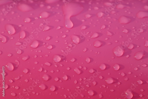 Drops of water after summer rain on pink color children's inflatable ball