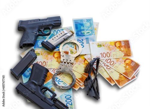 Two guns, police handcuffs, sunglasses on the background of Israeli New Shekel banknotes money. Semi automatic handguns firearm with mag on shekels with the 100, 200 NIS bills isolated on the white photo