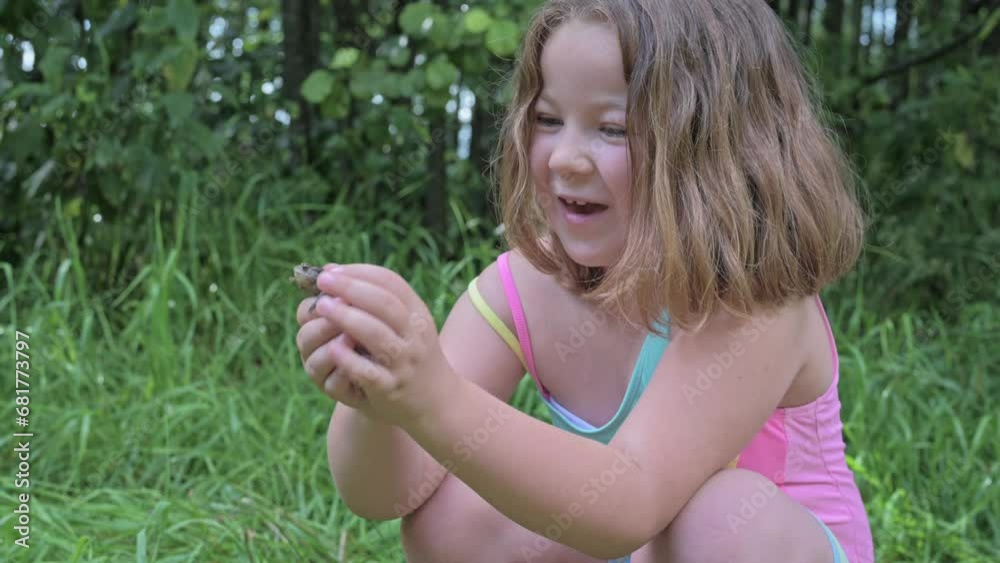 funny cute girl child playing on the beach with a frog in summer. High quality 4k footage funny cute girl child playing on the beach with a frog in summer. High quality 4k footage