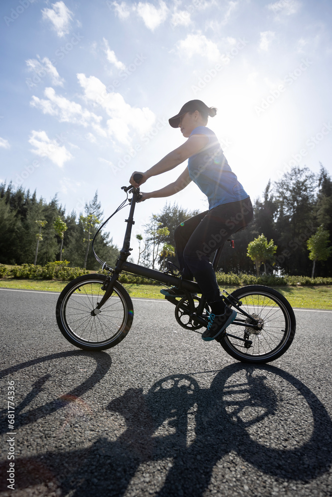 Fototapeta premium Riding folding bike on sunny seaside road