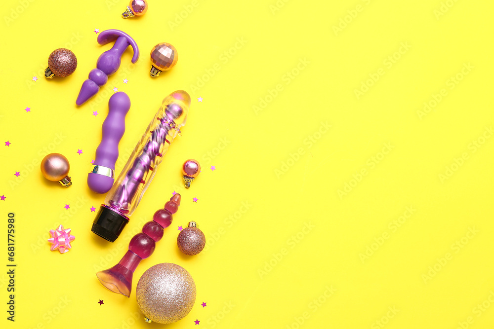 Fototapeta premium Sex toys and Christmas balls on yellow background