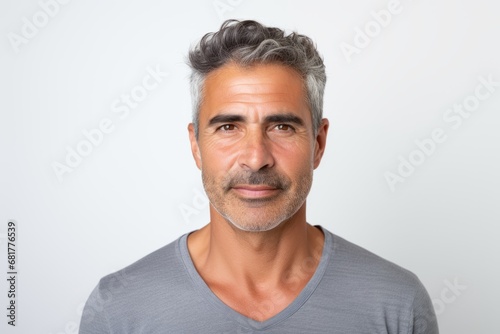 Handsome middle-aged man in grey t-shirt on grey background