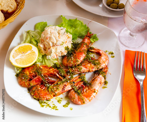 Image of delicious king shrimps and salad from potatoes at plate