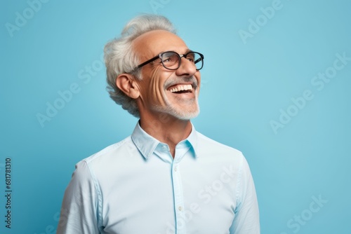 Cheerful senior man in eyeglasses laughing and looking at camera