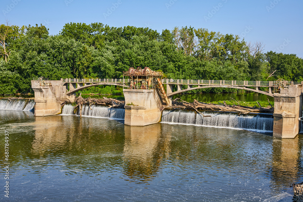 Maumee River Dam pool with logs going over waterfalls and rusty equipment Fort Wayne, IN