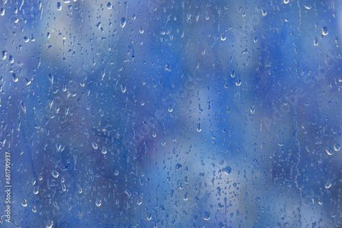 Raindrops on the window glass. Blurred background outside the window