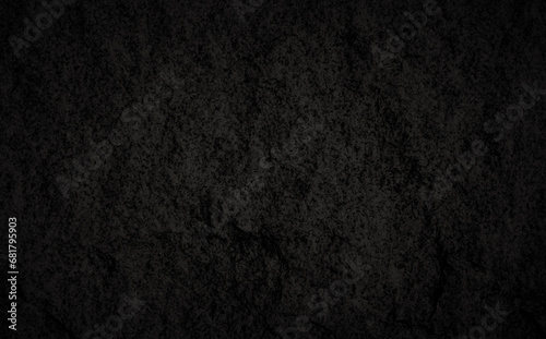 Close-up of a dark gray, almost black, solid fine-grained granite rock surface texture, front view. Abstract full frame natural textured background in black and white with copy space.