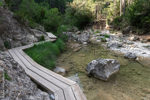 Wooden path over Matarrana river at The Parrizal spot in Beceite, Teruel, Spain photo