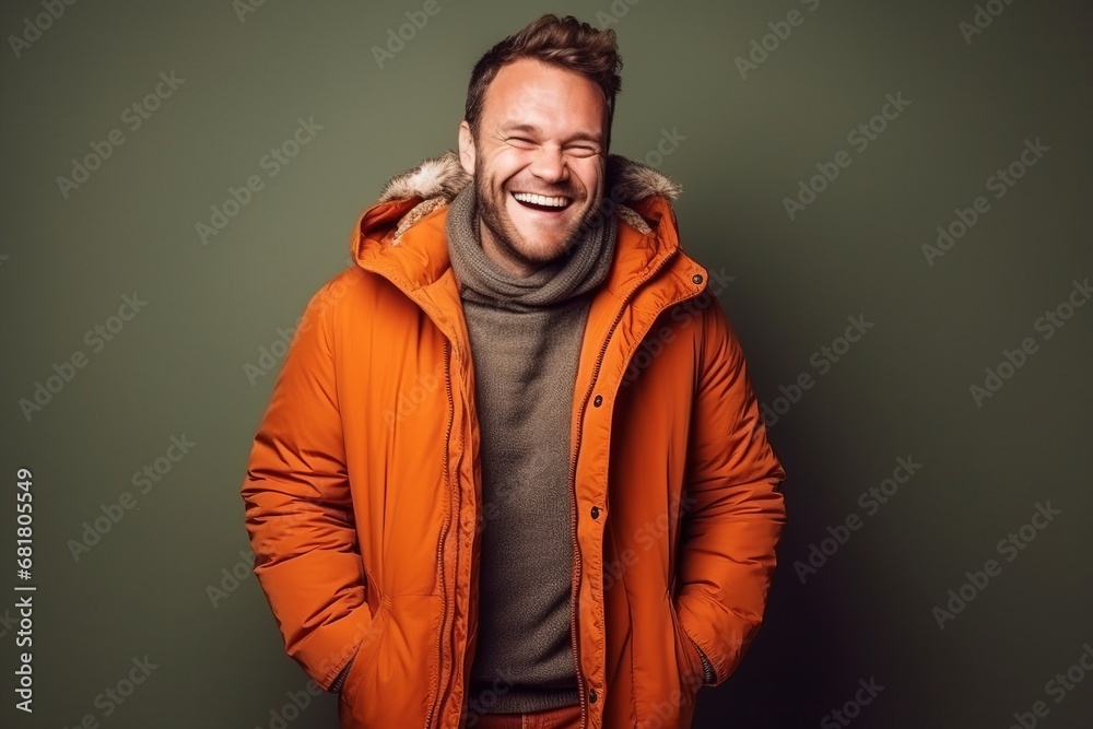 Portrait of a handsome young man laughing in an orange jacket. Portrait of a handsome young man laughing in an orange jacket.