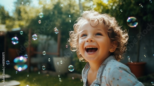 A little boy smiles thanks to the bubbles floating around him.