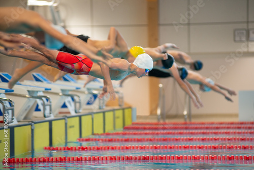 Boy swimmers start from the starting table in the pool