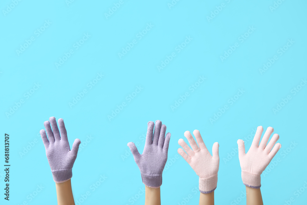 Female hands in warm gloves on color background