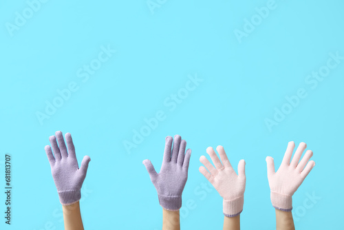 Female hands in warm gloves on color background