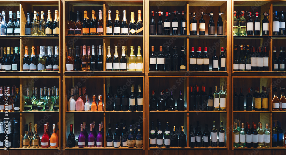 Front view of shelves with wine and champagne bottles in liquor store.