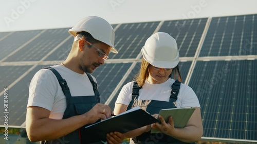 An engineer and a technician are discussing the result of a solar power plant