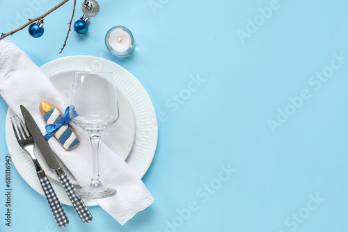 Festive table setting with Hanukkah decorations on blue background