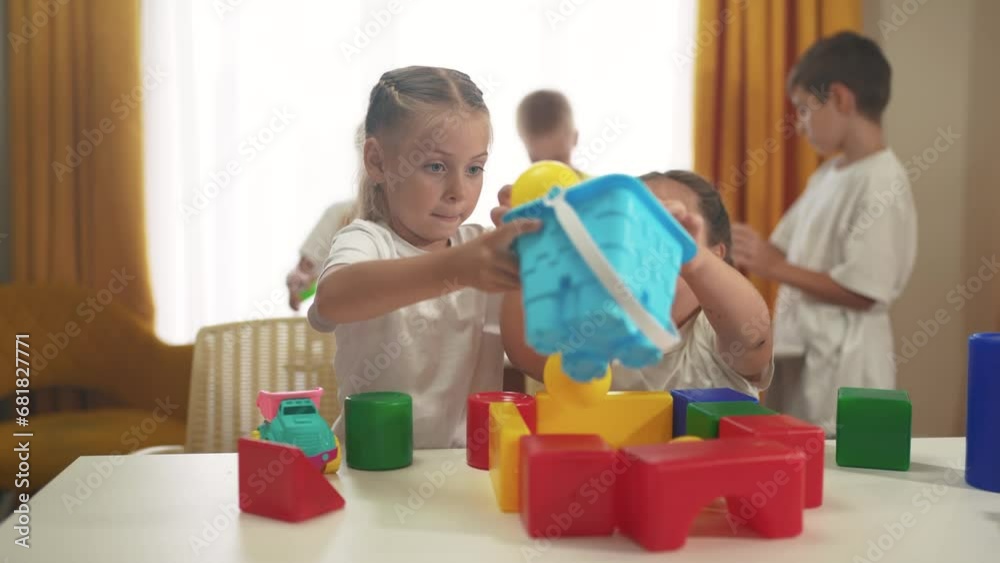 small lifestyle children play with toys at home. happy family childhood dream concept. a group of little kids develops playing with colorful cubes and pyramids. educational games with colored toys small lifestyle children play with toys at home. happy family childhood dream concept. a group of little kids develops playing with colorful cubes and pyramids. educational games with colored toys