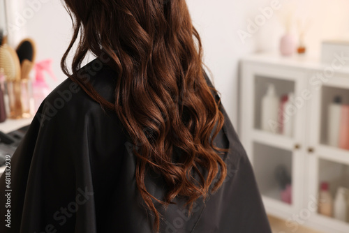 Woman with curly hair sitting in salon, closeup