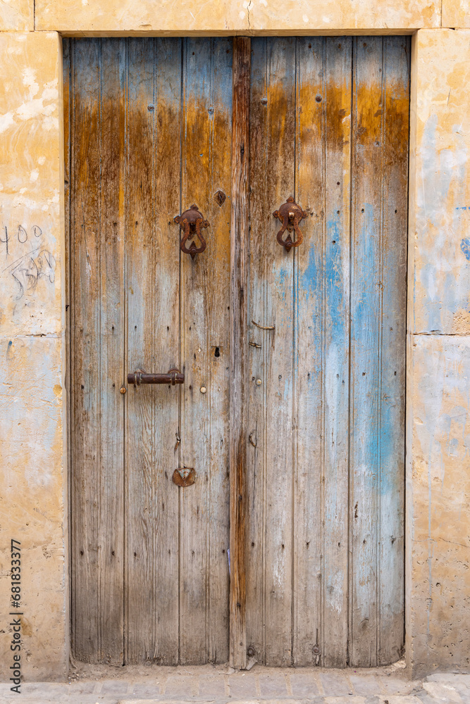 A weathered wooden door with blue paint.