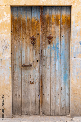 A weathered wooden door with blue paint. © Emily_M_Wilson