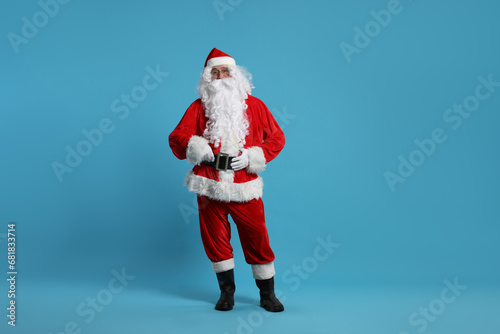 Merry Christmas. Santa Claus posing on light blue background