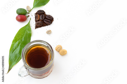 Amantes del café. Día Internacional. Corazón formado con granos tostados, cerezas y hojas del cafeto. Vista superior o cenital sobre superficie blanca y espacio para copiar.   photo