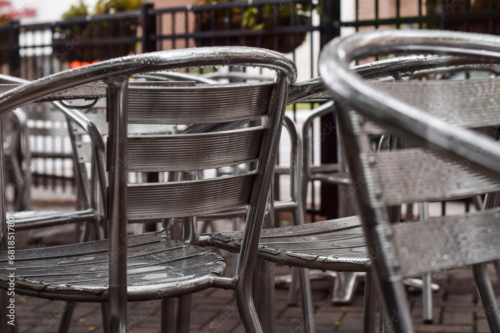Aluminum metal patio chairs on a restaurant outdoor patio on a rainy day Aluminum metal patio chairs on a restaurant outdoor patio on a rainy day
