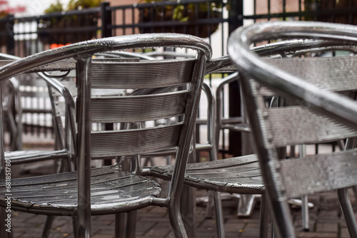Aluminum metal patio chairs on a restaurant outdoor patio on a rainy day