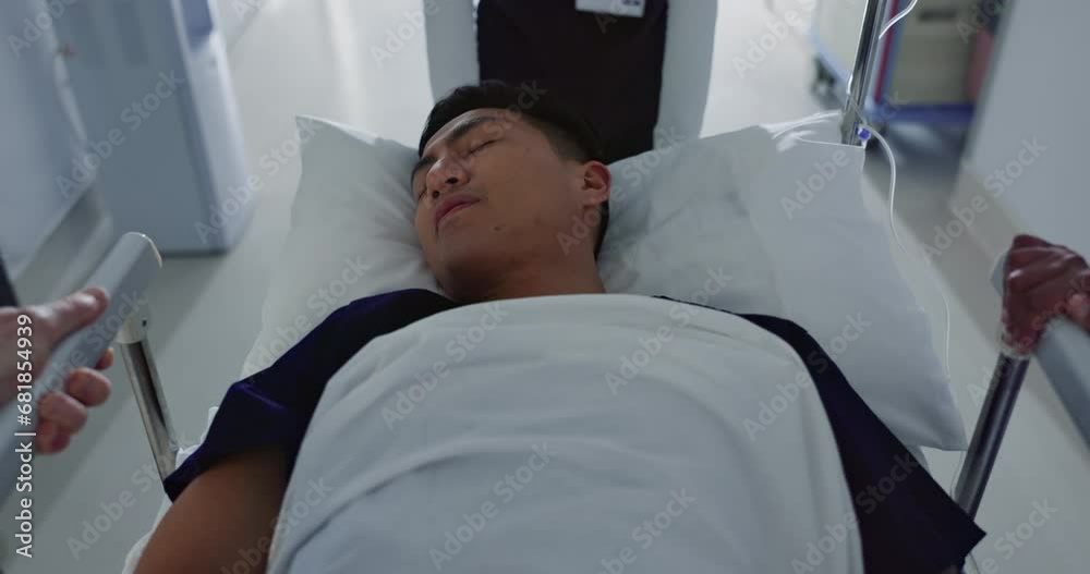 Asian man, patient and push bed in hospital for surgery, emergency or medical problem in corridor. Medicine, professional or person with stretcher for wellness, service and risk in clinic or job Asian man, patient and push bed in hospital for surgery, emergency or medical problem in corridor. Medicine, professional or person with stretcher for wellness, service and risk in clinic or job