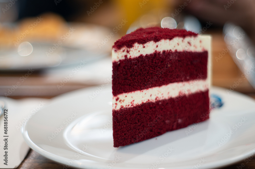 A red velvet cake is placed on a white ceramic plate. A red velvet cake is placed on a white ceramic plate.