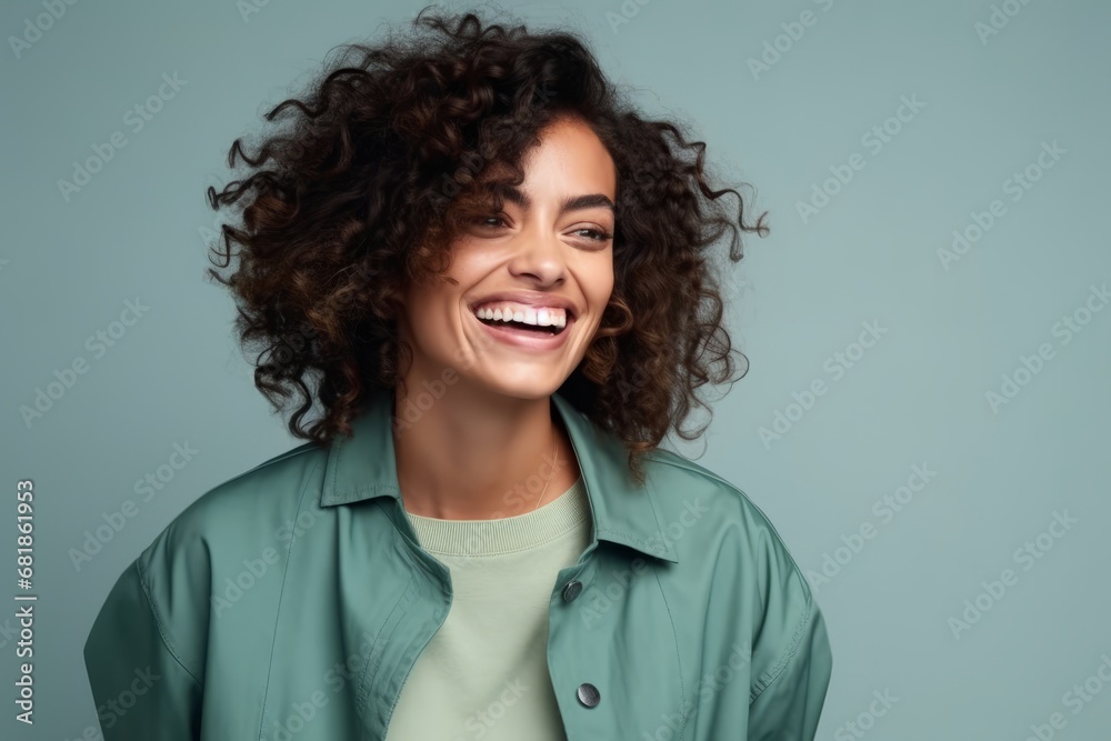 Portrait of a happy young african american woman laughing against blue background Portrait of a happy young african american woman laughing against blue background