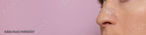Banner Closeup Nasal Strip on Female Nose on Pink Background. Adhesive Bandage for Better Breathing. Stop Drug-Free Snoring Solution. Copy Space For Text. Horizontal Plane photo