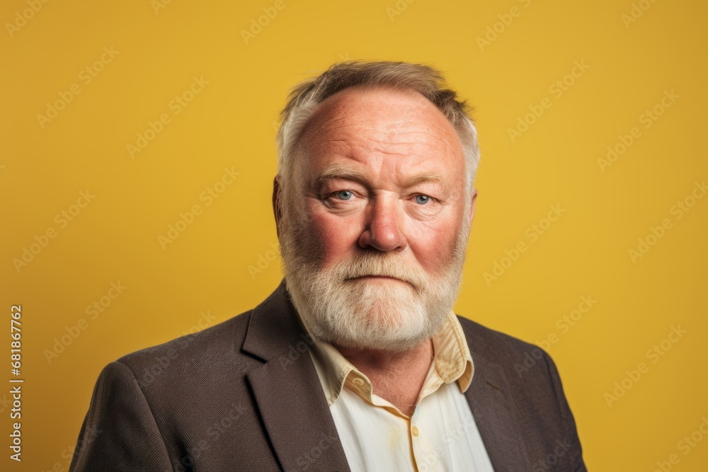 Portrait of senior man with grey beard and mustache on yellow background Portrait of senior man with grey beard and mustache on yellow background