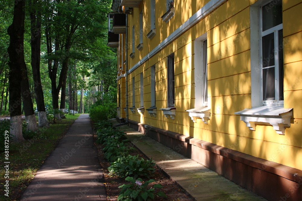 Shaded pedestrian path along the facade of a residential building
