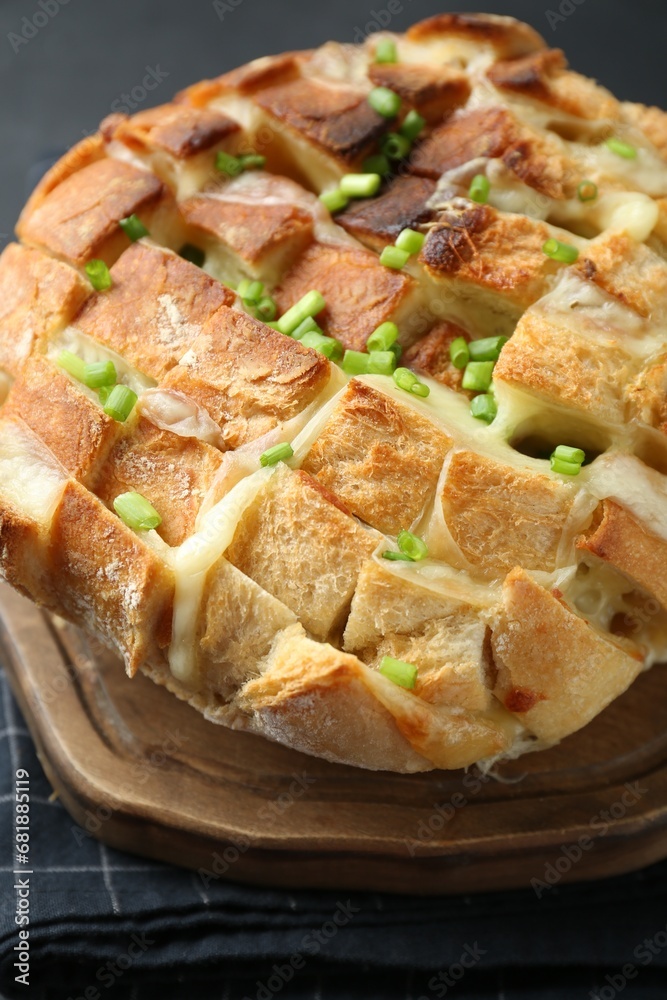 Freshly baked bread with tofu cheese and green onions on table, closeup