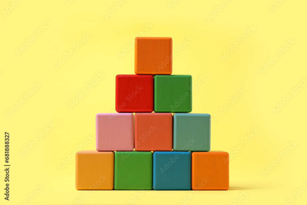 Pyramid of blank colorful cubes on yellow background Pyramid of blank colorful cubes on yellow background