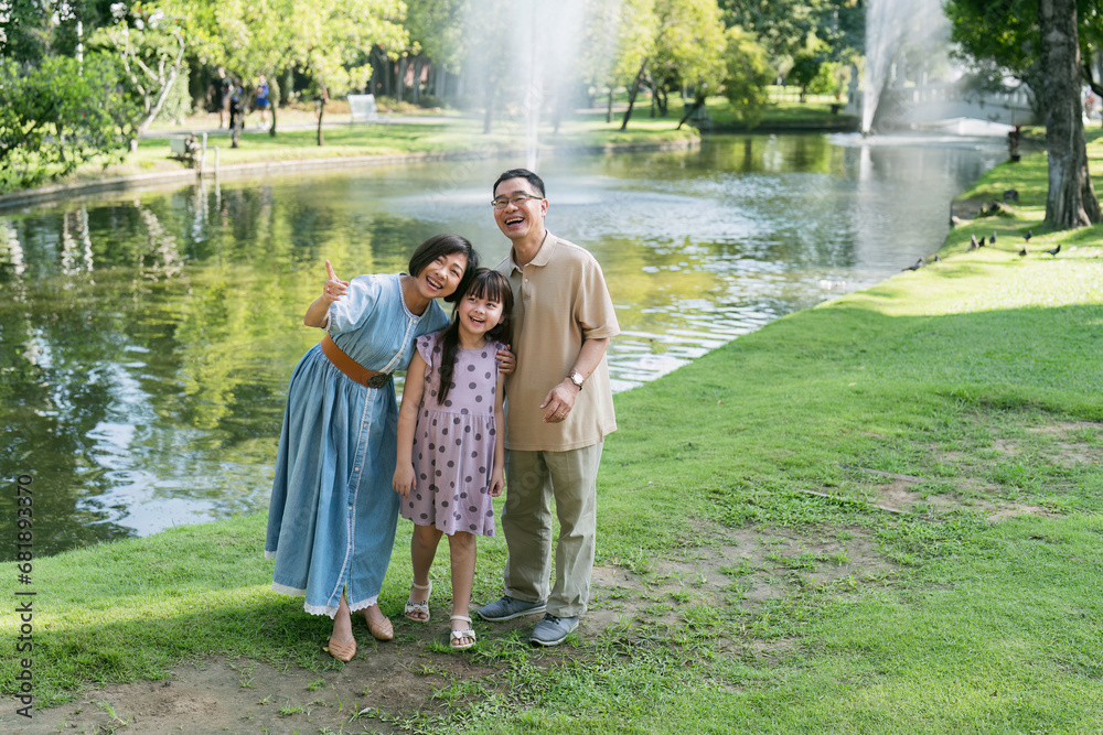 happy smiling family grandparent and grandchild picnic together outside at park