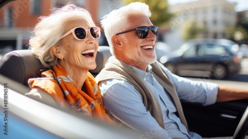Happy old couple driving an old timer cabrio through an touristic town on their vacation
