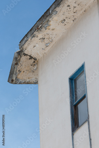 A concrete block hanging from an abandoned apartment block roof