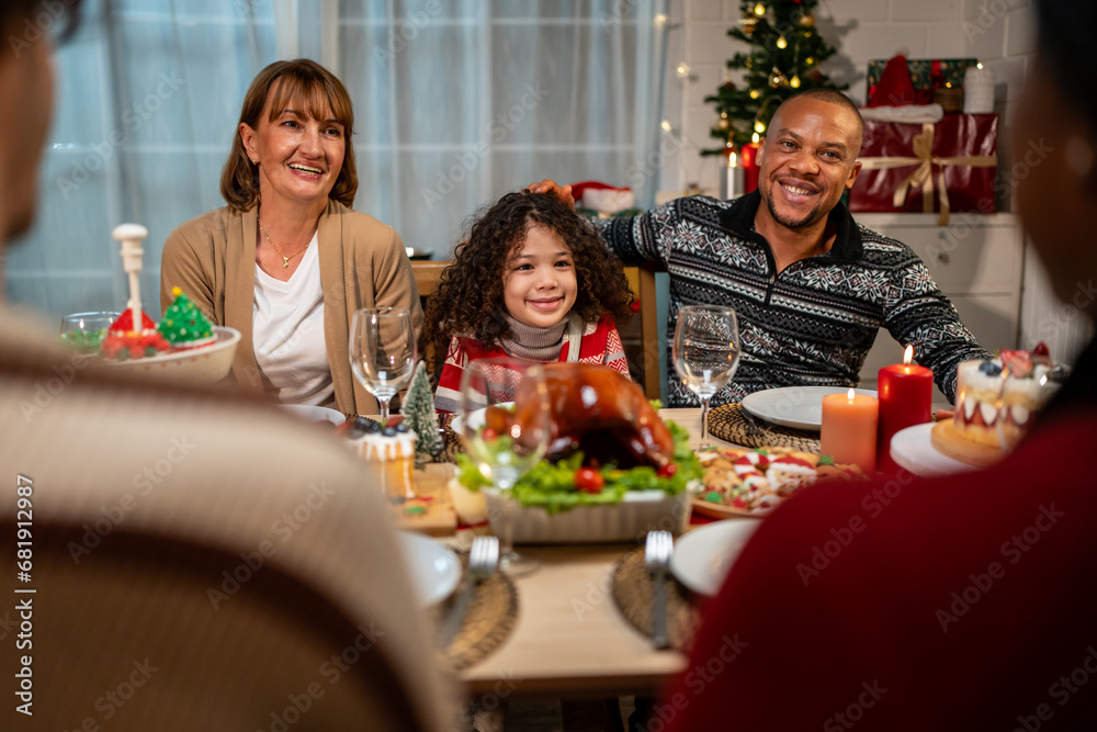 Multi-ethnic big family celebrating Christmas party together in house. 
