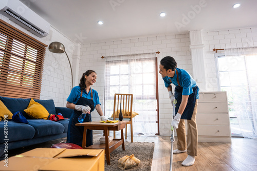 Asian young man and woman cleaning service worker work in living room. photo