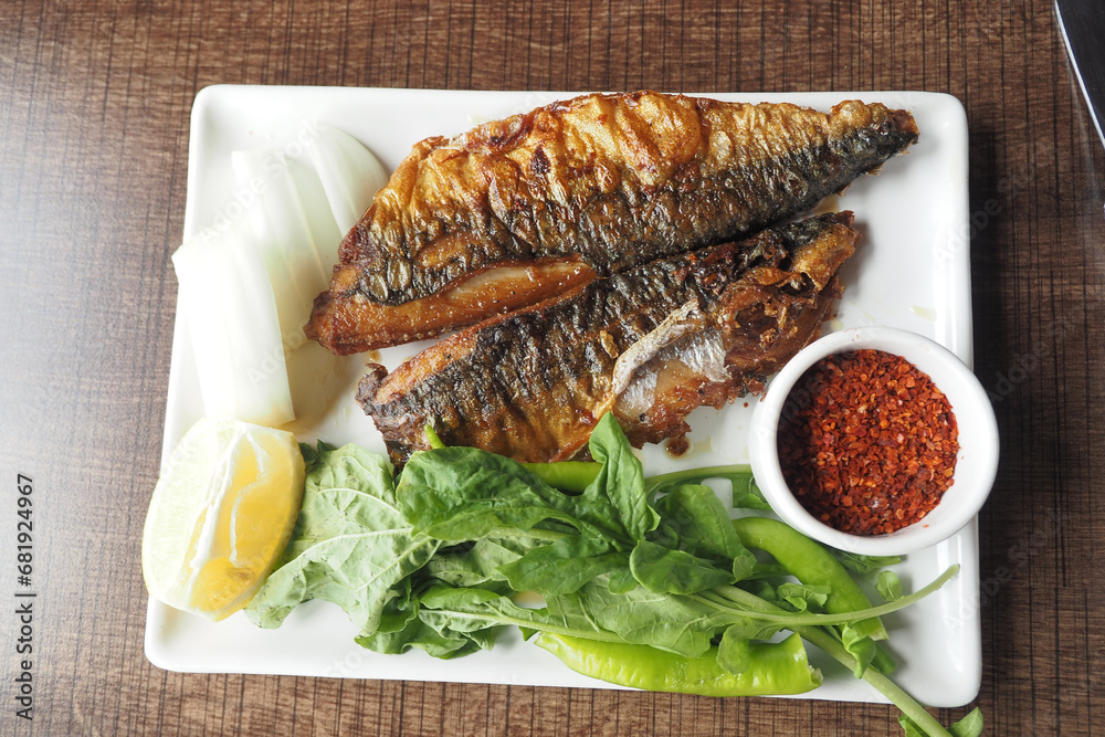fried fish served with lettuce , lemon on a plate fried fish served with lettuce , lemon on a plate