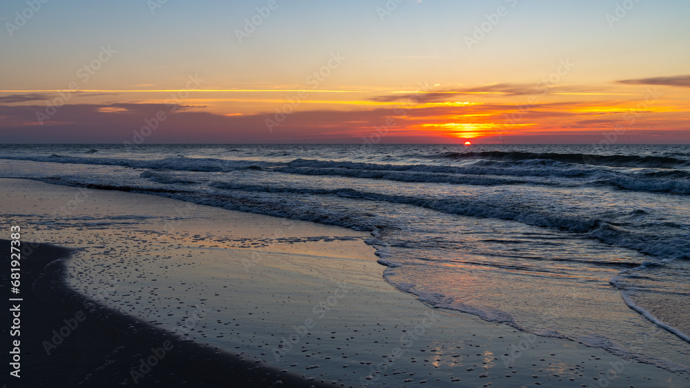 Sunr Rises on Right over Beach with Reflections on Wet Sand