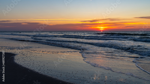Sunr Rises on Right over Beach with Reflections on Wet Sand