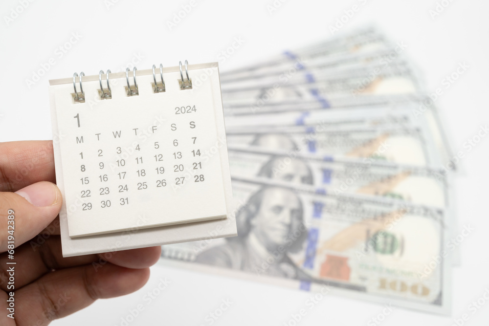 Obraz premium 2024 Jan Calendar and US dollars. Pension Concept. Bonus Money. isolated on white background.